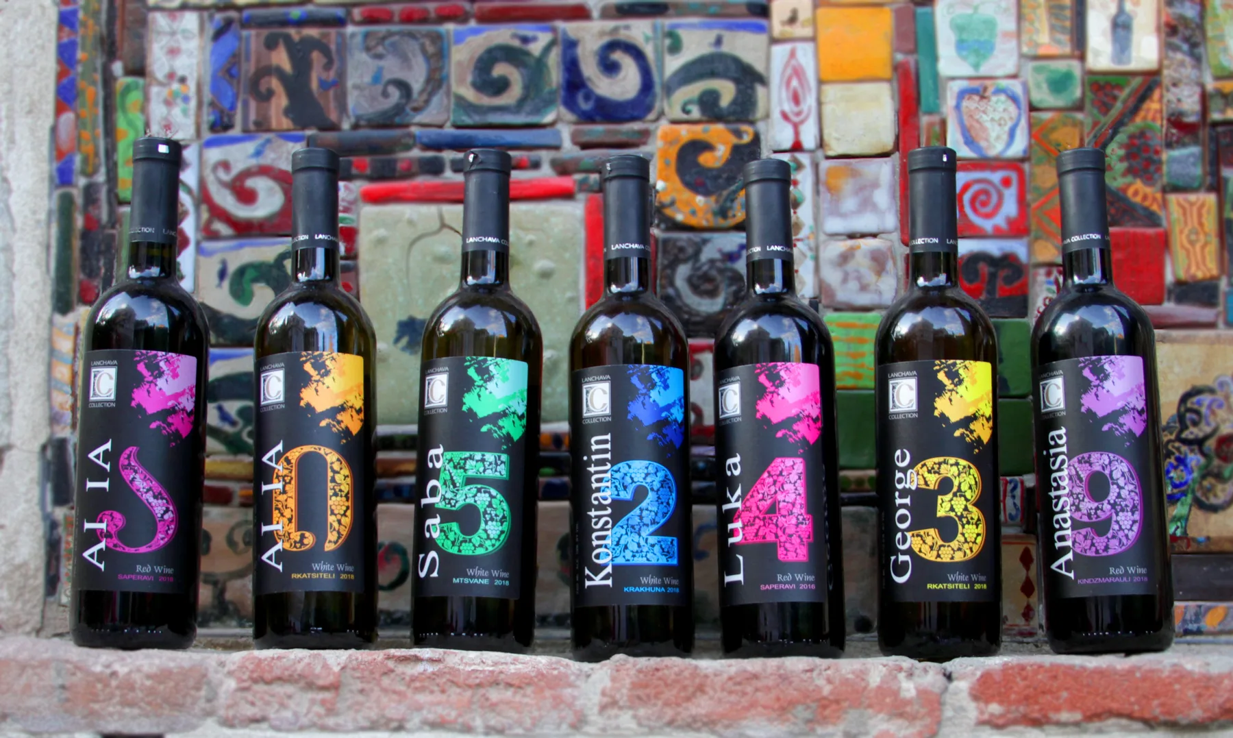 Seven Lanchava Collection bottles, from Ai Ia to Anastasia, lined up against a colorful mosaic tile wall