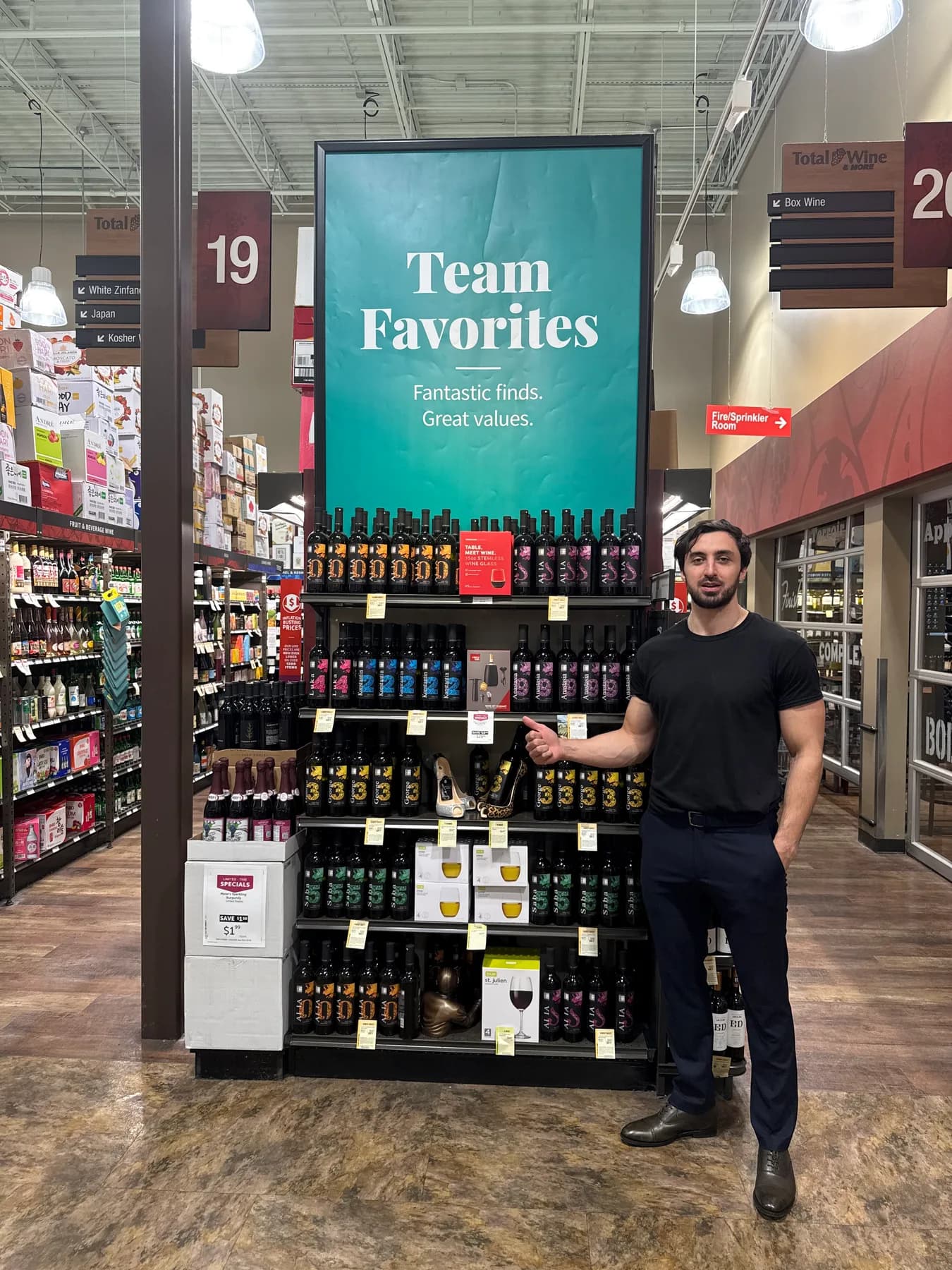 A person beside a Team Favorites display stocked with Lanchava Collection wines